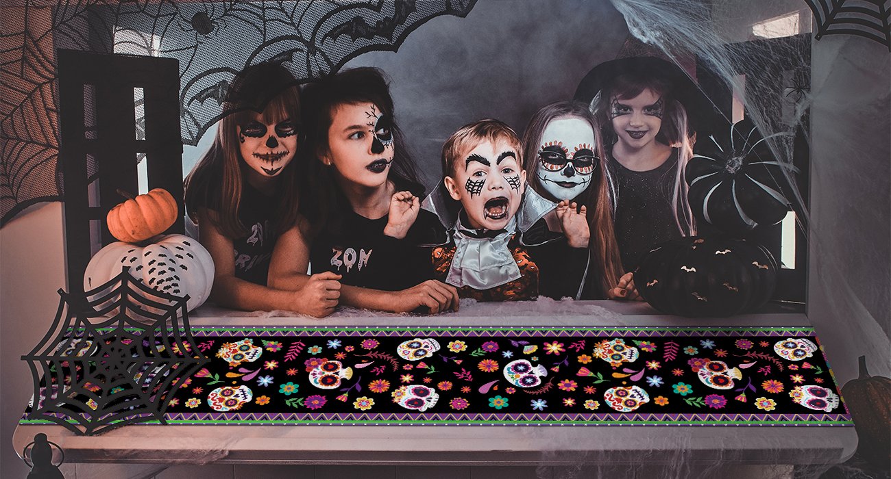 Day of the Dead table runner with sugar skull print displayed on a table with children in Halloween costumes