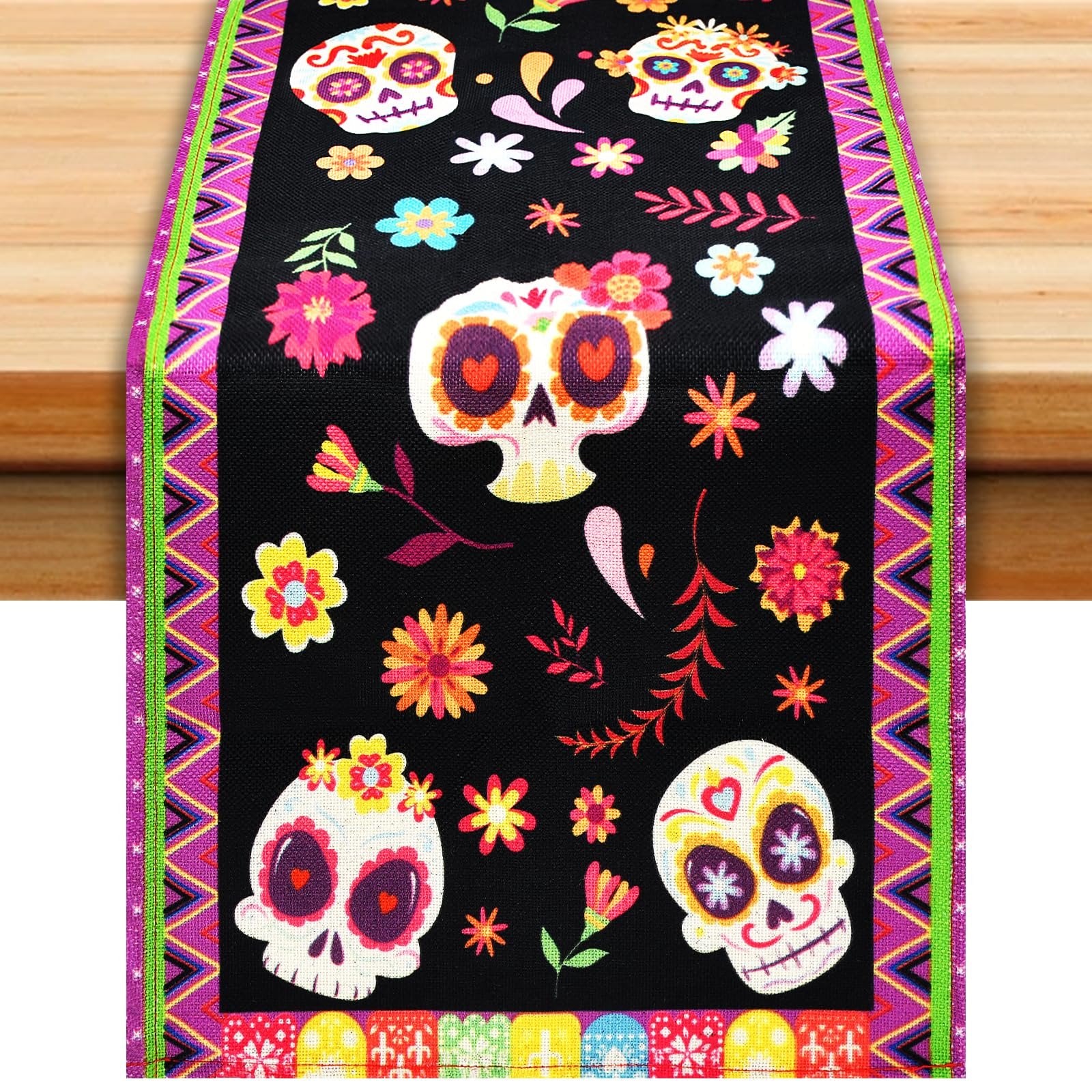 Day of the Dead themed table runner with sugar skull and floral print, displayed on a wooden table.