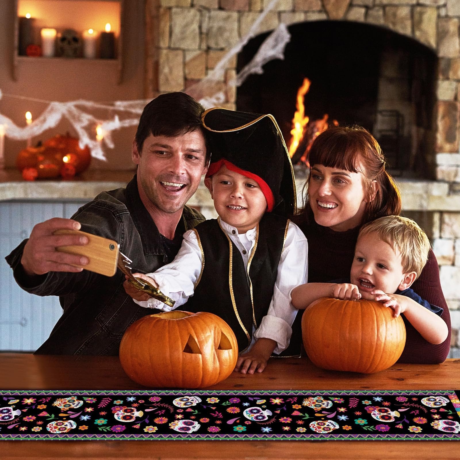 Family taking a selfie with pumpkins and a Halloween-themed table runner