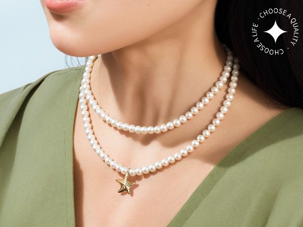 Woman wearing a double strand pearl necklace with a gold starfish charm