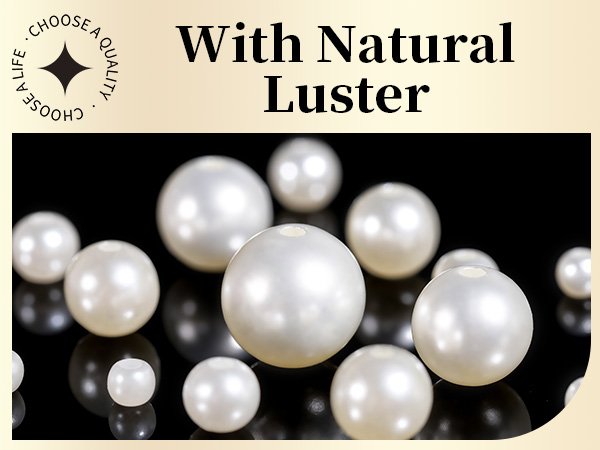 Assortment of white pearls of various sizes scattered on a reflective black surface.