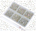 Set of crystal AB glass flatback rhinestones in a divided container with a picking pen, scattered rhinestones around the container.
