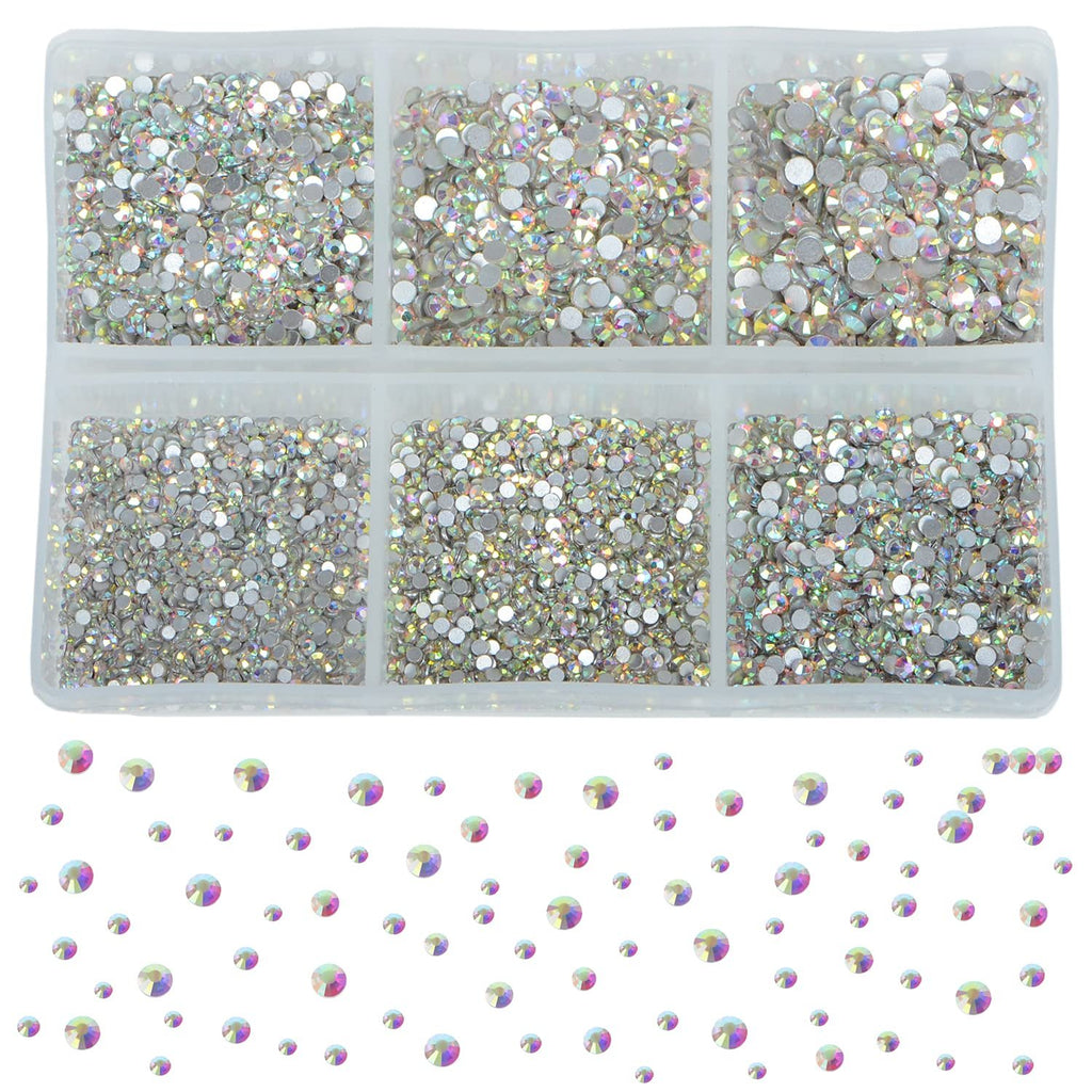 Crystal AB glass rhinestones in six compartments of a plastic organizer tray, with scattered rhinestones below