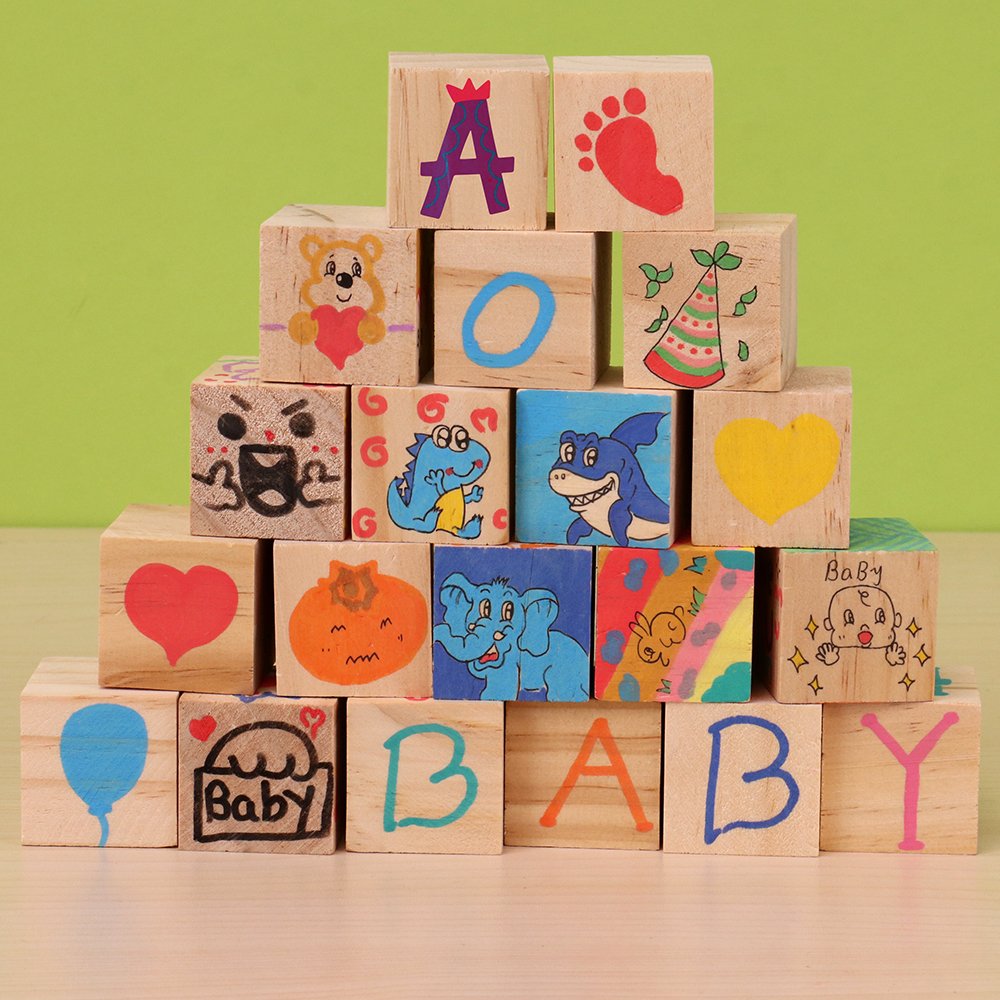 Stack of wooden blocks with various drawings and letters, including 'A', 'O', 'Baby', and cartoon animals.