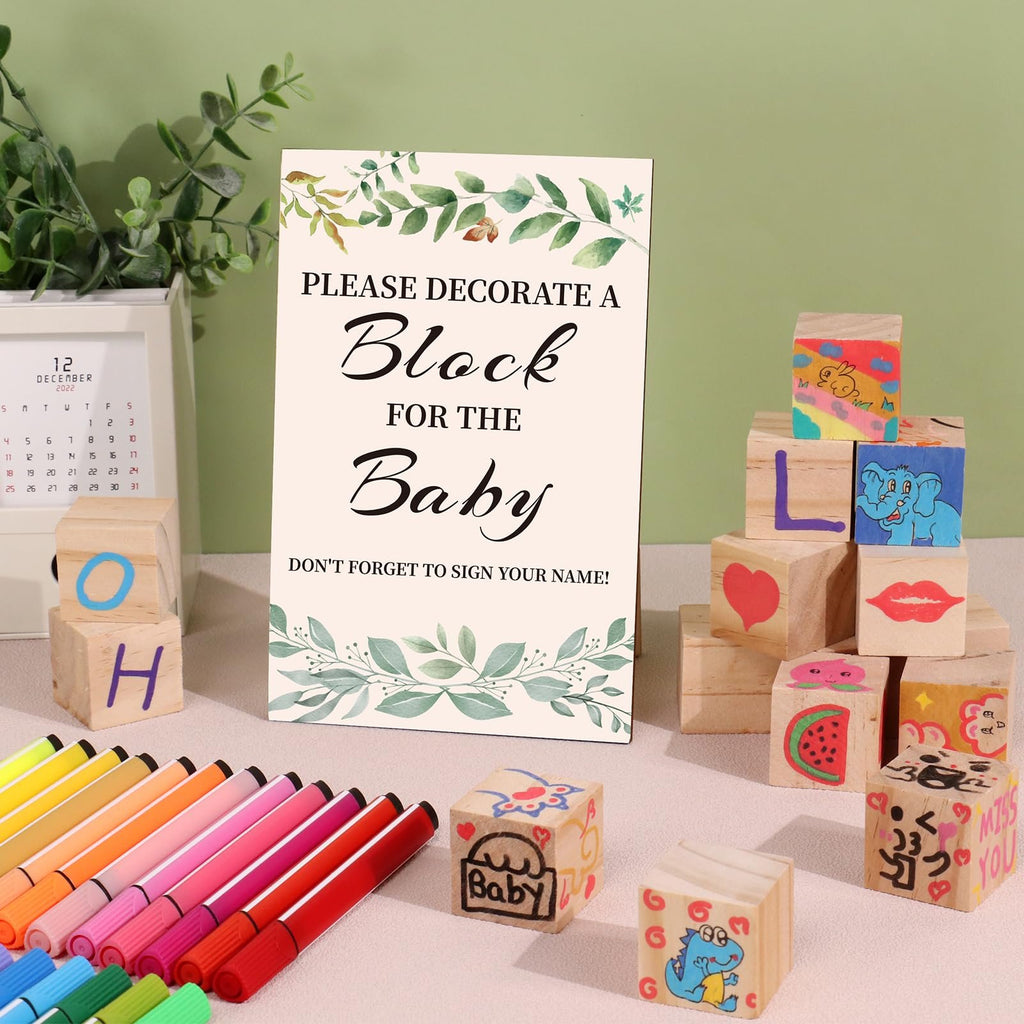 Baby shower block decorating kit with sign, wooden blocks, and markers on a table.