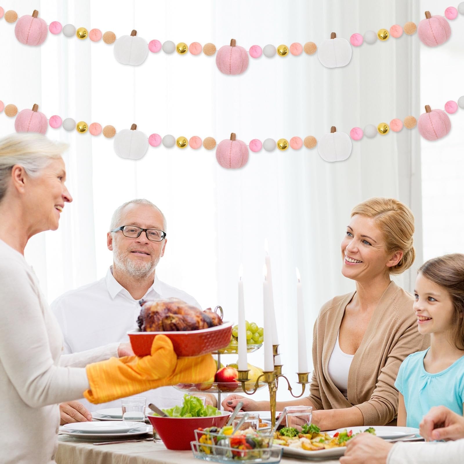 Family enjoying a Thanksgiving dinner with a felt pumpkin garland hanging in the background