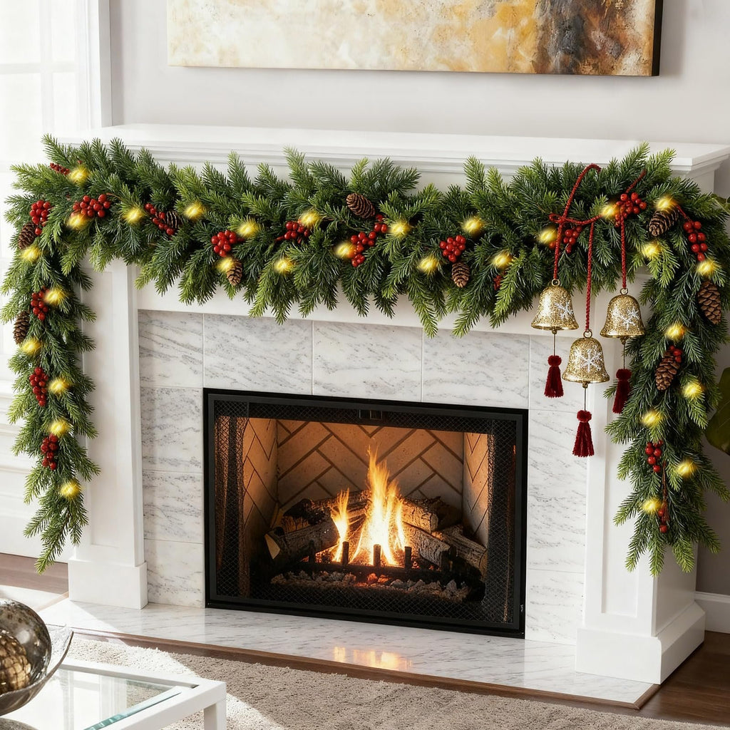 Christmas garland with warm white lights, pinecones, and red berries draped over a fireplace mantel with a fire burning inside.