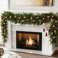 Christmas garland with warm white lights, pinecones, and red berries draped over a fireplace mantel with a fire burning inside.