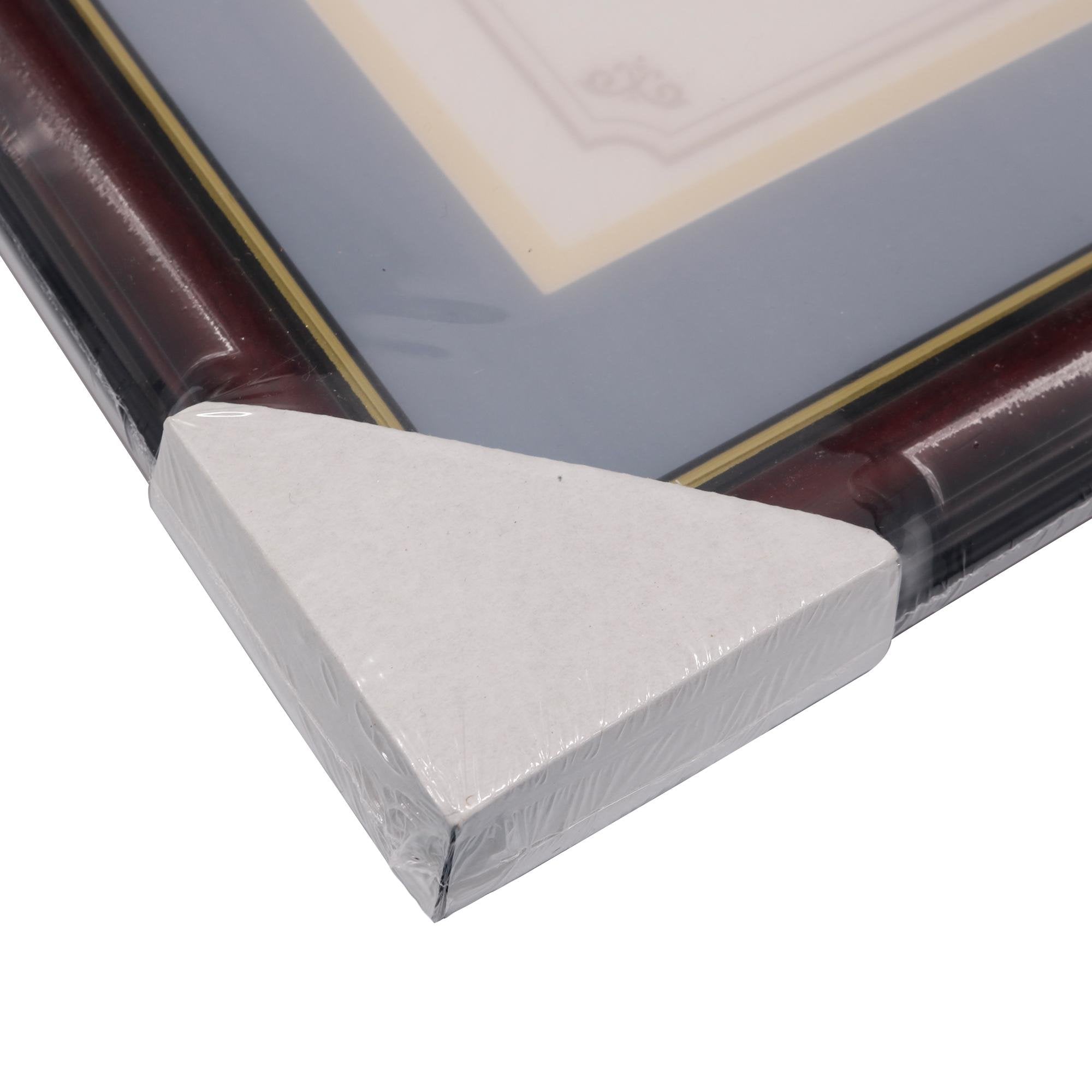 Close-up of a certificate frame corner, showing cherry wood finish and gold trim, wrapped in protective plastic.