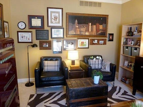 Living room scene with two black leather chairs, a trunk coffee table, and a bookshelf filled with items.
