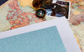 Vintage map with a compass and a photograph of a person by the sea, with blank pages and a textured blue sheet.