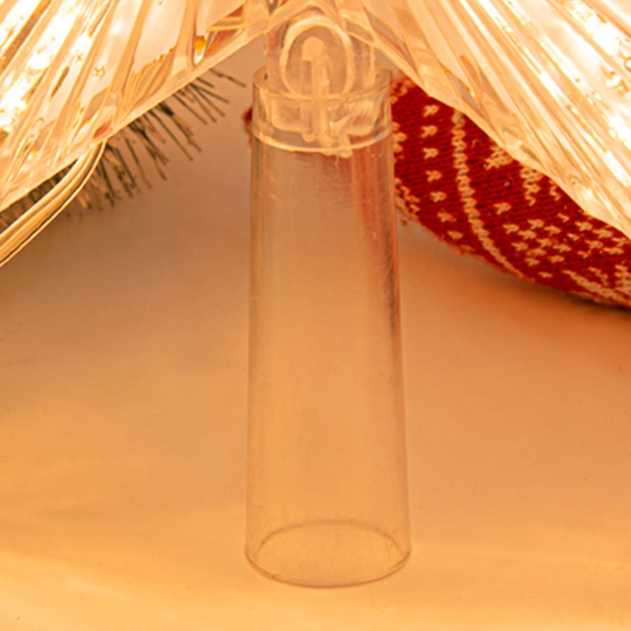Close-up of a clear plastic tree topper base with warm white LED lights and a red and white patterned fabric visible behind it.
