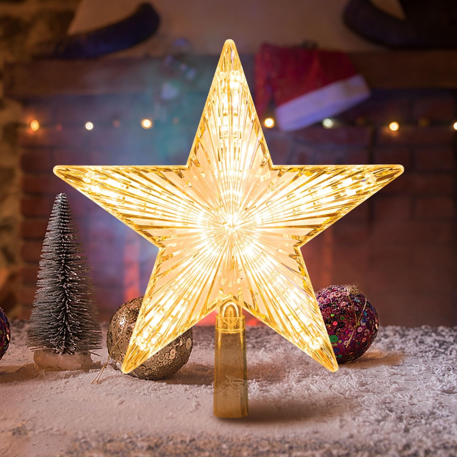 Warm white LED star tree topper with ribbed prismatic design, illuminated and placed on a snowy surface with Christmas decorations.