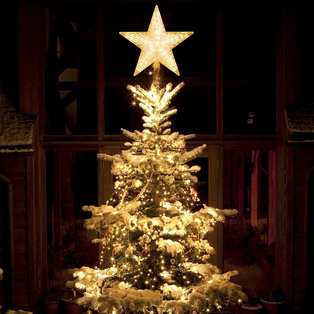 Warm white LED star tree topper with 30 lights on a snow-covered Christmas tree at night.