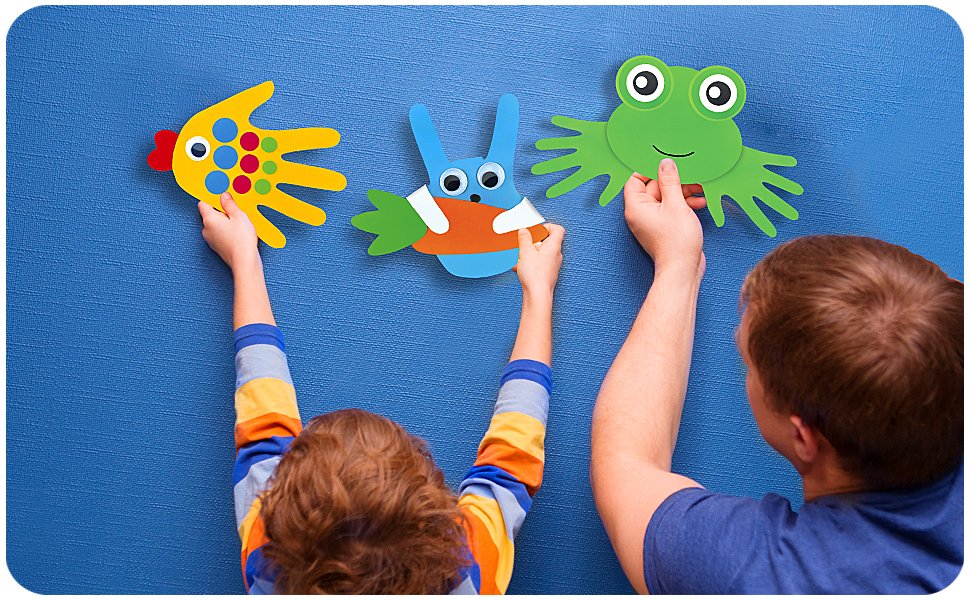 Child and adult hands holding colorful handprint animal crafts against a blue textured background.