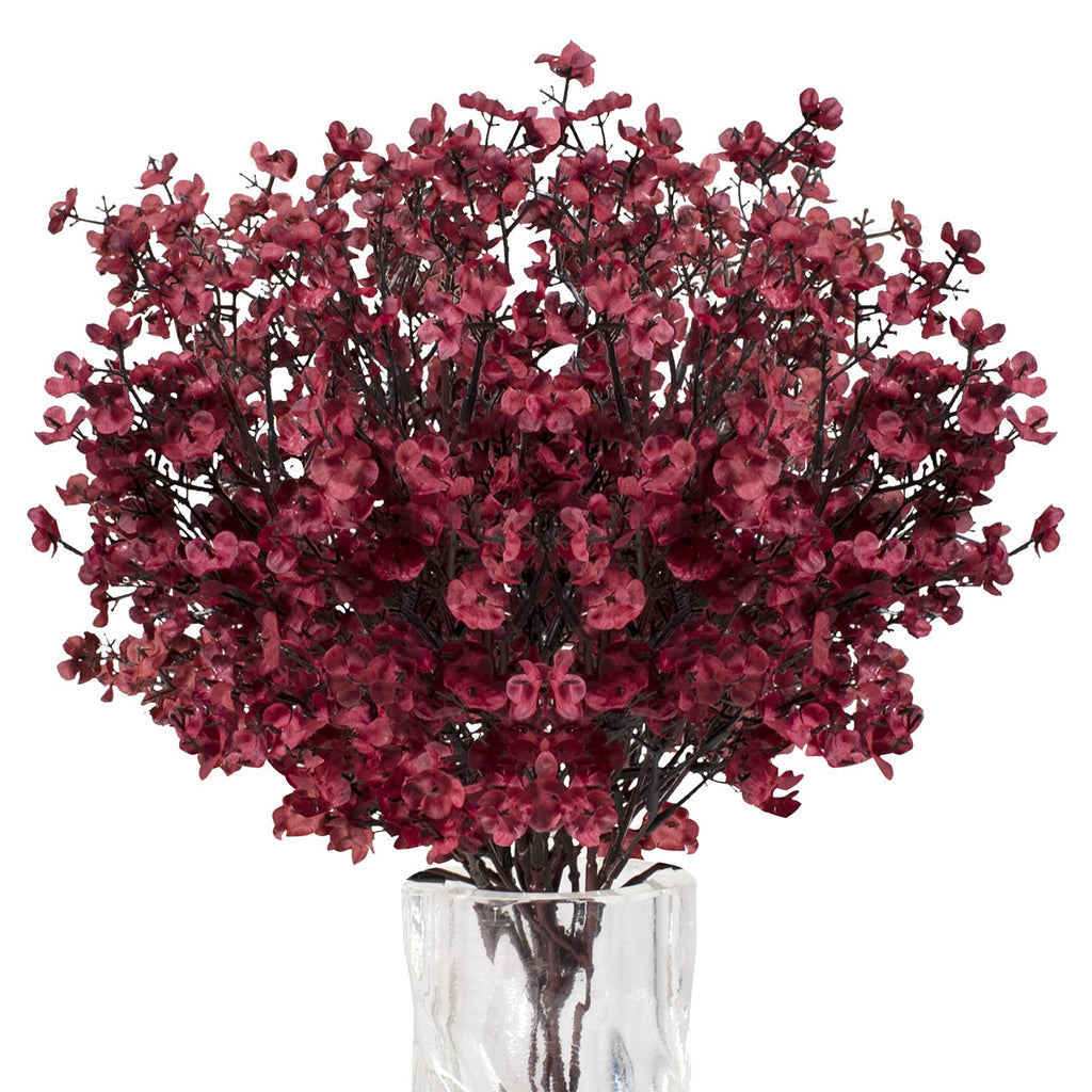 Burgundy artificial baby's breath flowers in a clear glass vase, close-up view