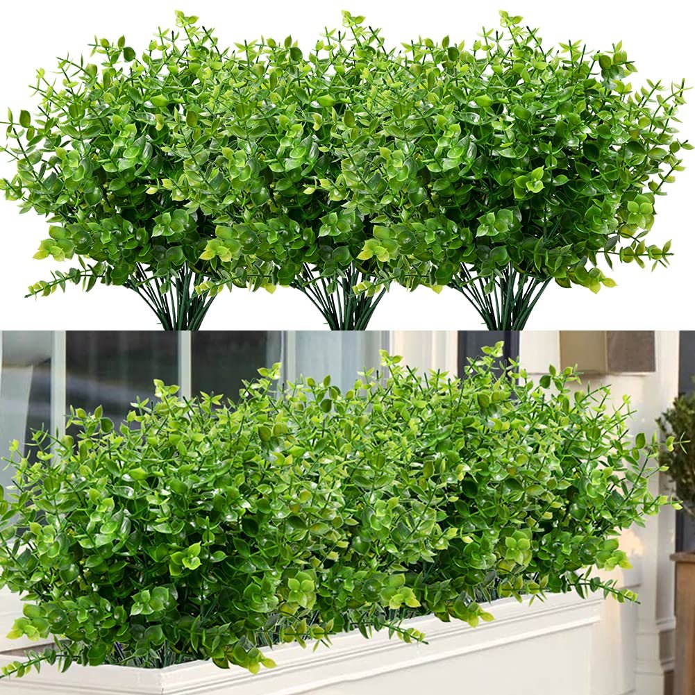 Eight bundles of artificial boxwood stems arranged in two rows, top row on white background, bottom row in a planter box.