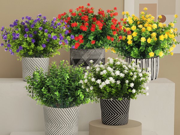 Five potted artificial plants in various colors including purple, red, yellow, white, and green, arranged on shelves.