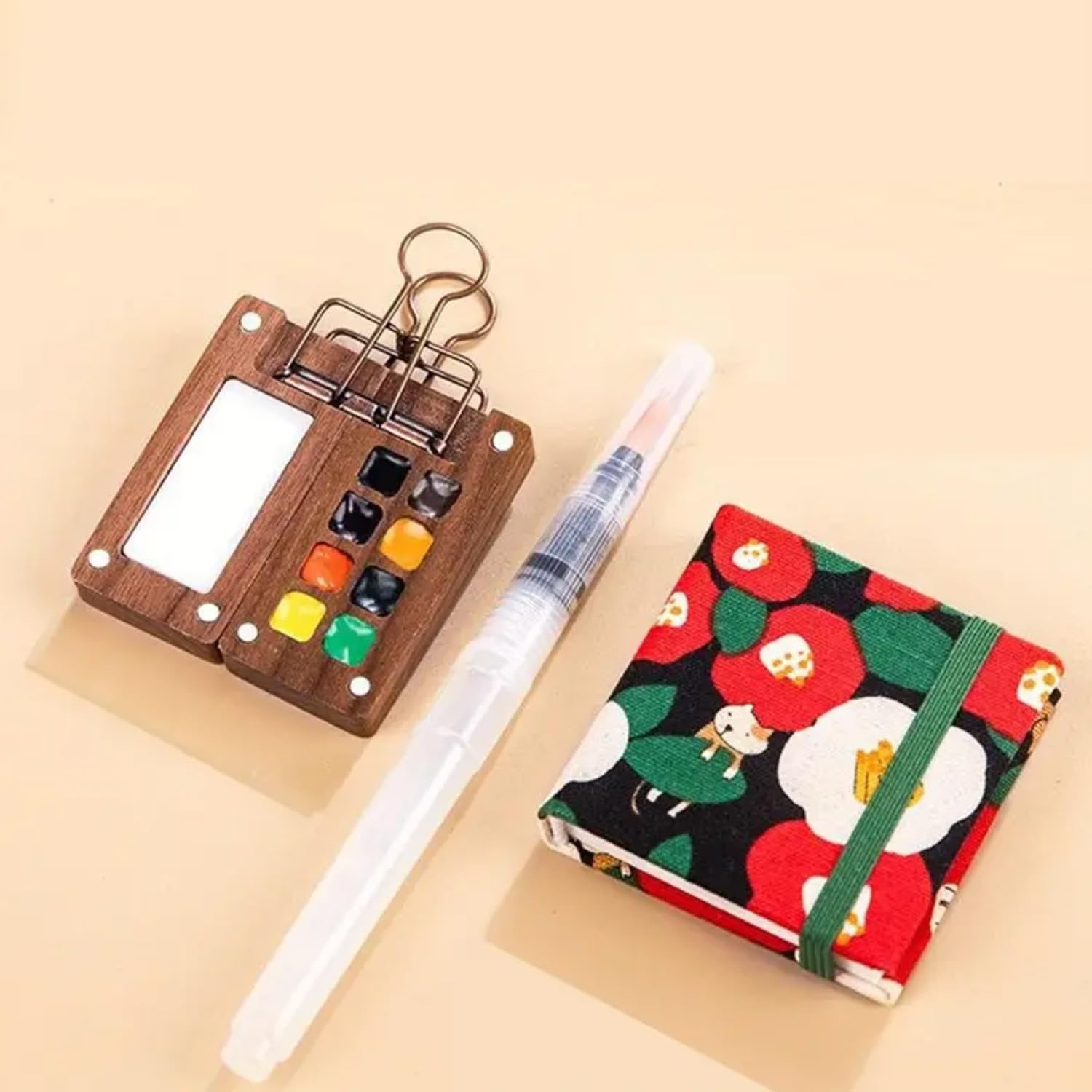 Mini watercolor paint travel set with wooden palette, water brush, and floral sketchbook