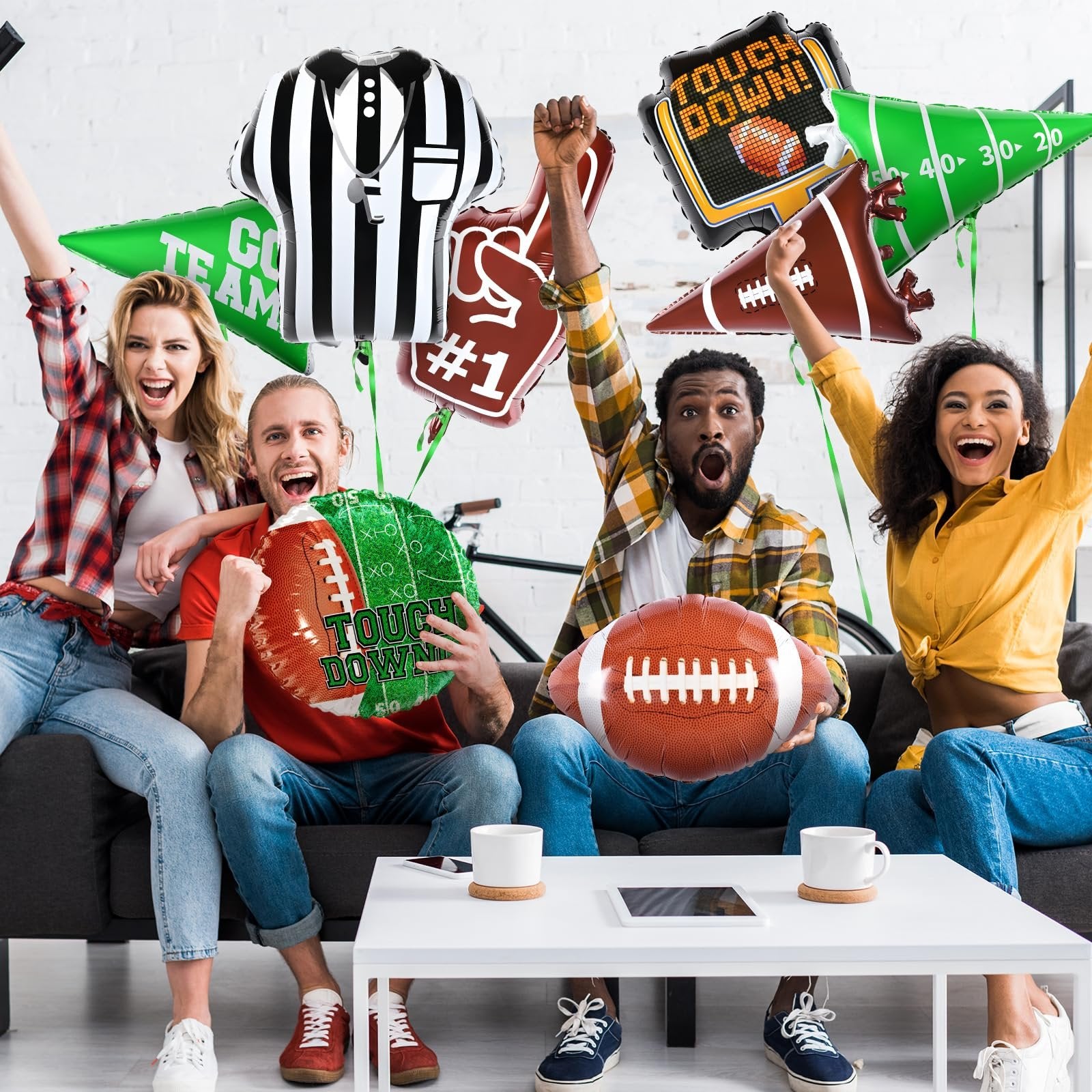 Four people celebrating while holding football-themed balloons including a referee shirt, foam finger, and touchdown designs.