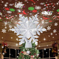 Silver snowflake tree topper projecting Christmas patterns onto ceiling above decorated Christmas tree