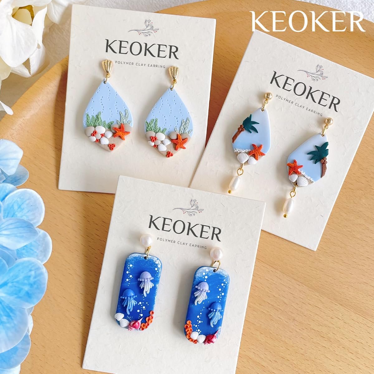 Three pairs of handmade polymer clay earrings with ocean themes, displayed on cards.