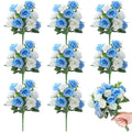 Eight artificial rose bouquets, blue and white silk flowers with green leaves, one bouquet held by a hand.