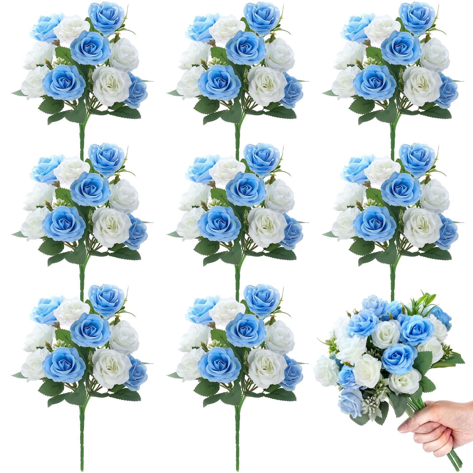 Eight artificial rose bouquets, blue and white silk flowers with green leaves, one bouquet held by a hand.