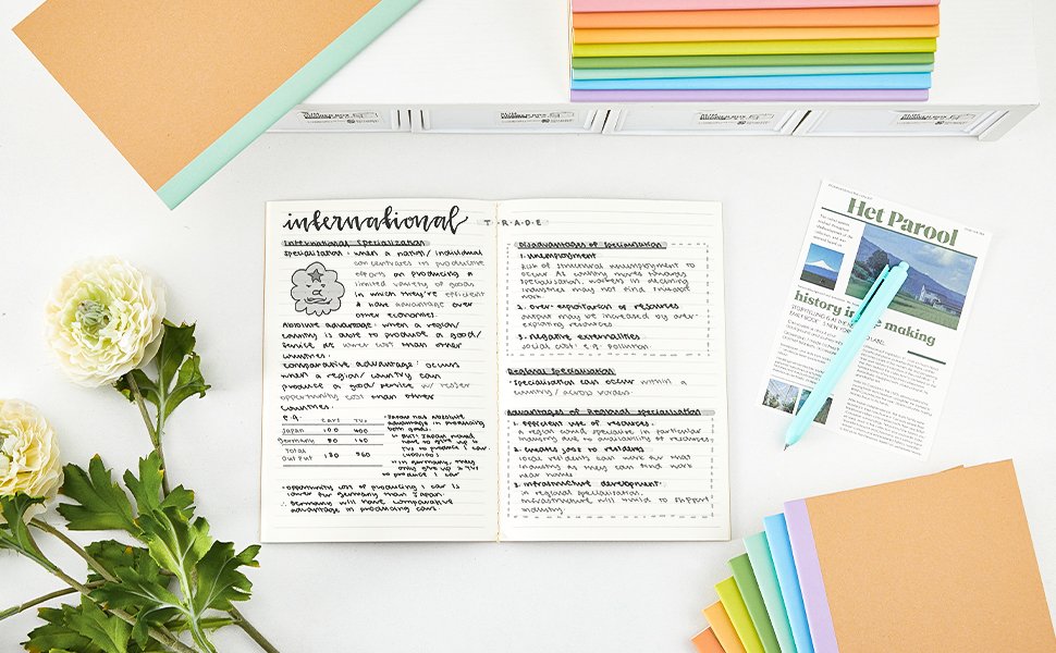 Open composition notebook with handwritten notes on international specialization, next to a pen and a mock newspaper.