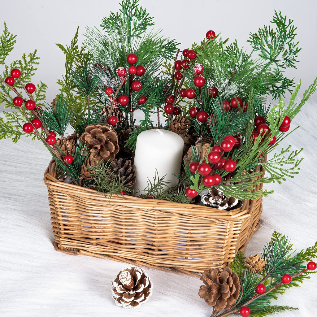 Christmas arrangement in a wicker basket with pine cones, red berries, and a white candle.