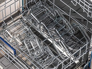 Set of glass food storage containers with lids arranged in a dishwasher rack