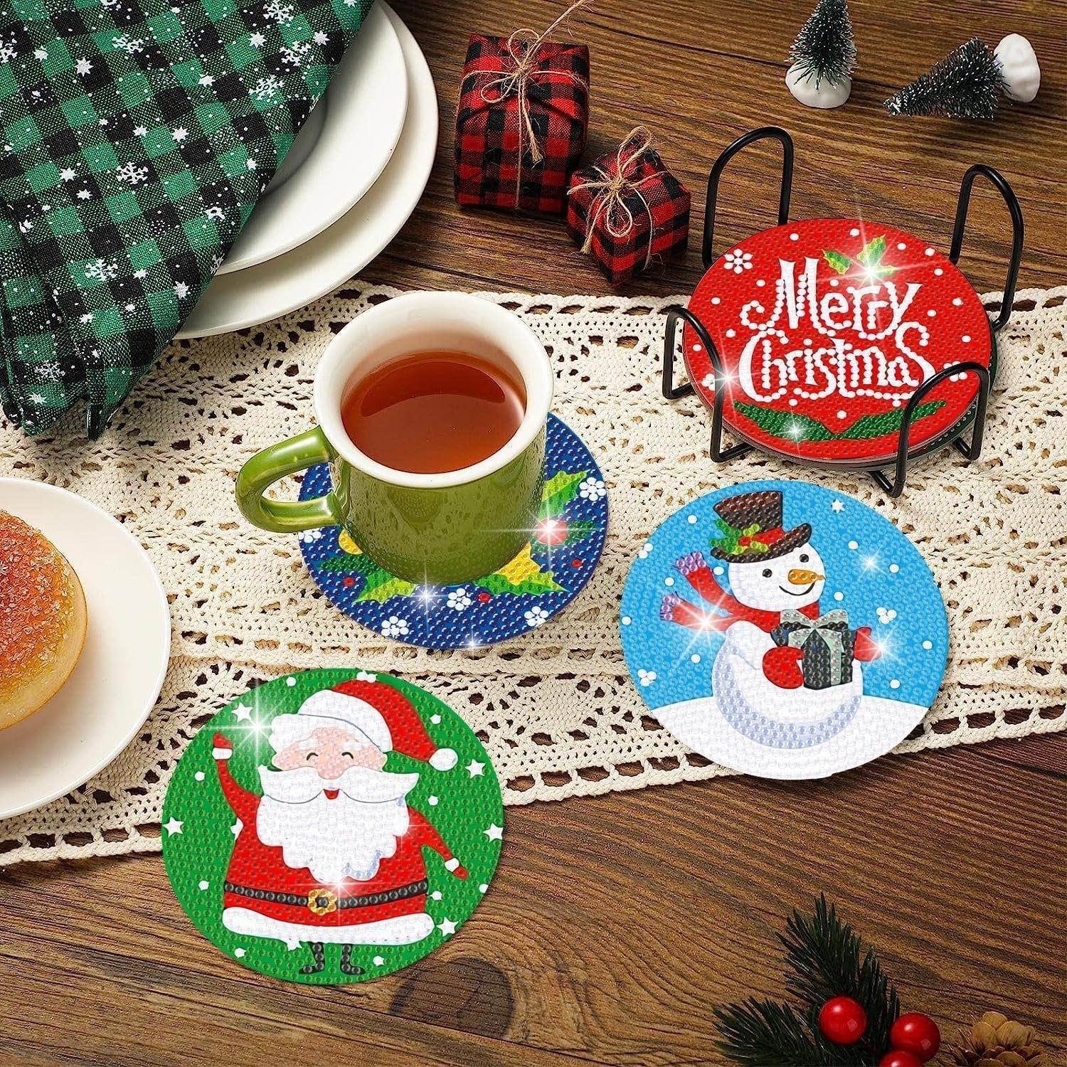 Diamond art coasters with Christmas designs including Santa, snowman, and Merry Christmas text, displayed with a mug and holder.