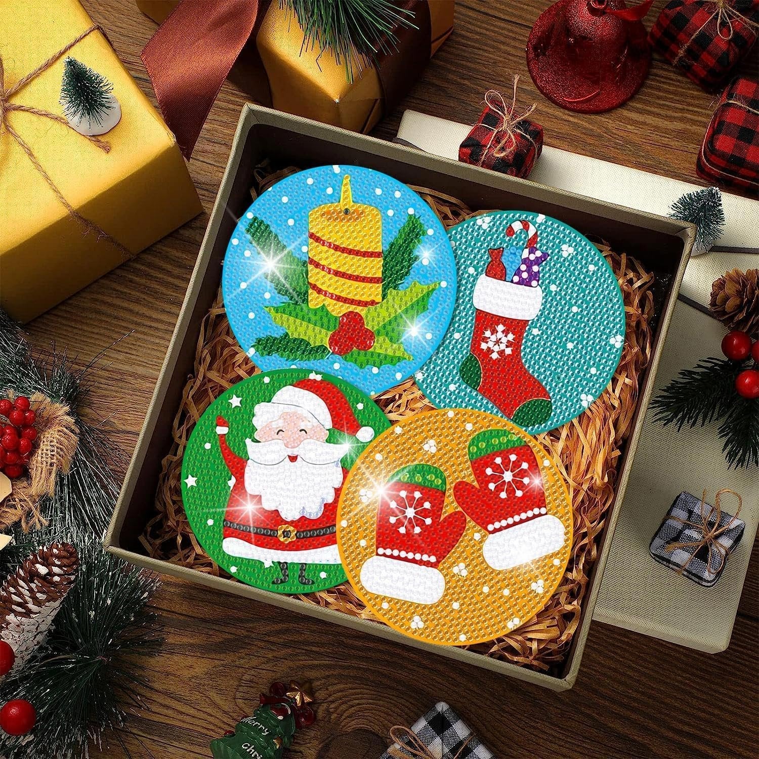 Diamond art coasters with Christmas designs including Santa, candle, stocking, and mittens, displayed in an open box with festive decorations.