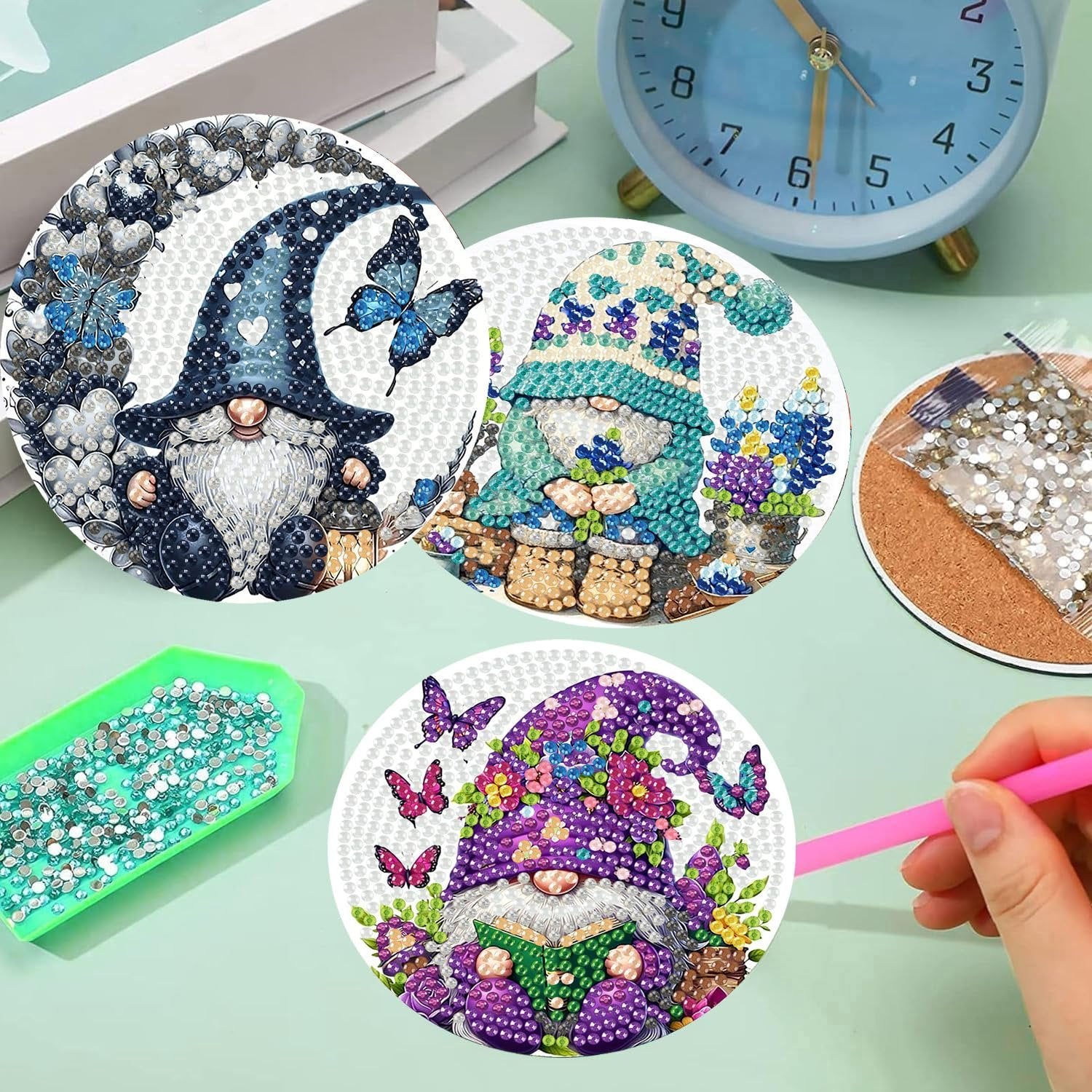 Diamond art coasters kits with gnomes and butterflies, plus diamond beads and a tool.