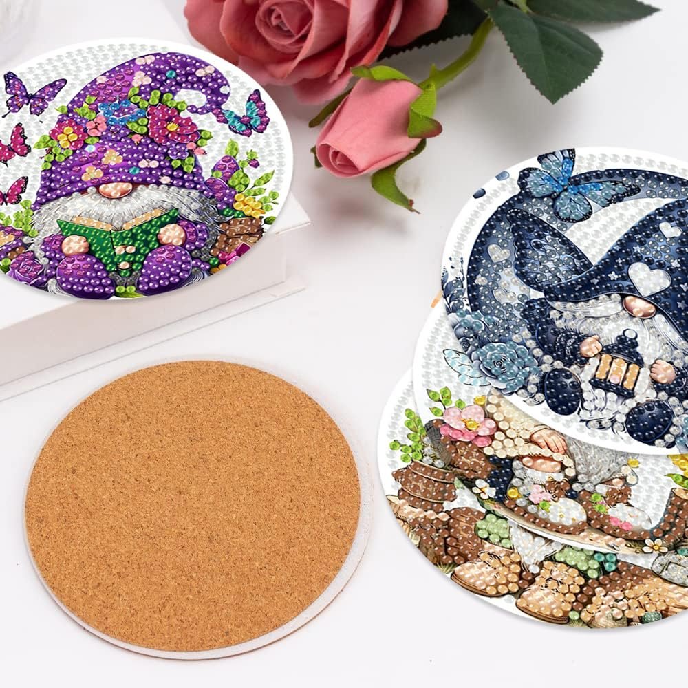 Diamond art coasters featuring gnomes and butterflies, with a cork backing visible.
