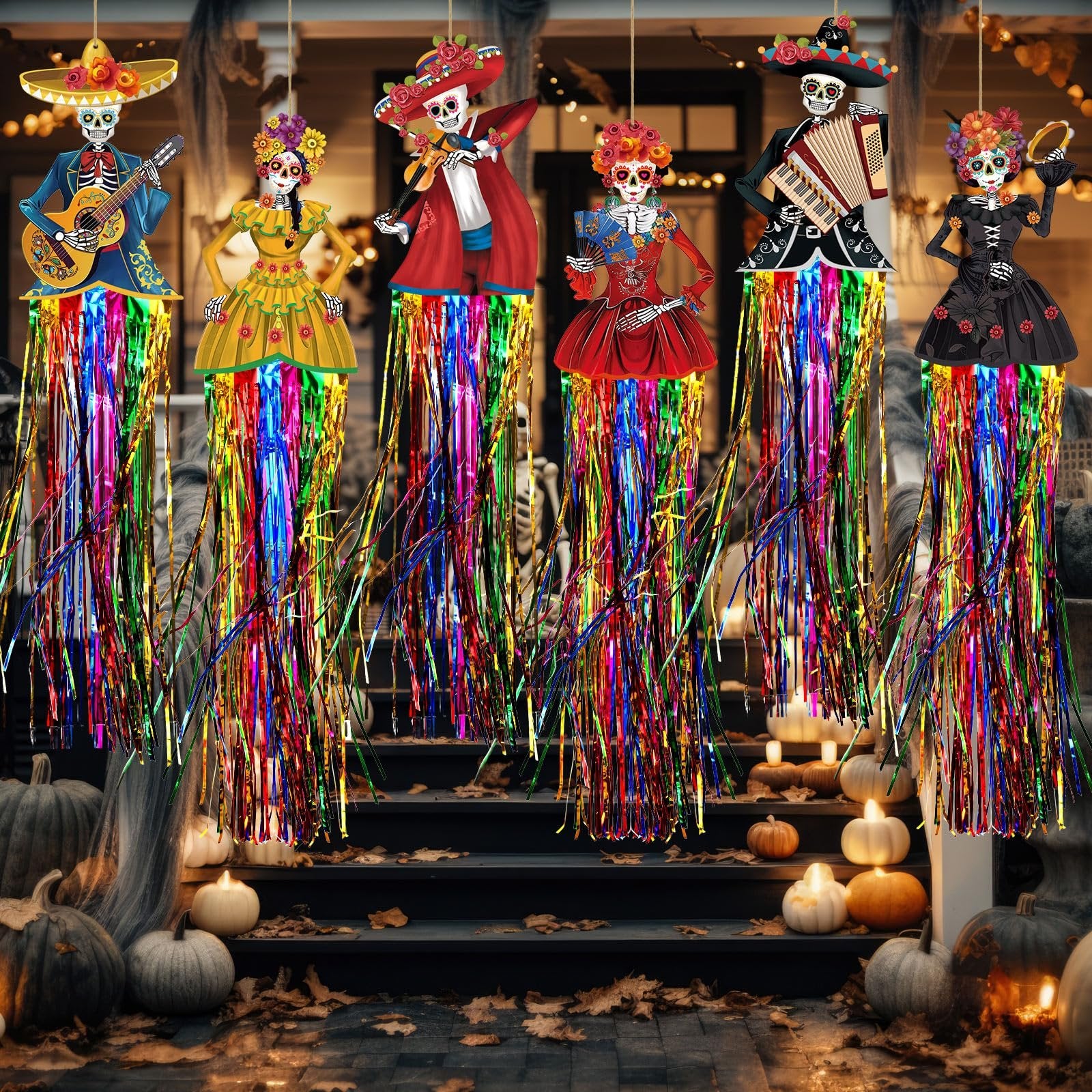 Day of the Dead sugar skull hanging decorations with colorful fringe, displayed on a porch with pumpkins and fall leaves.
