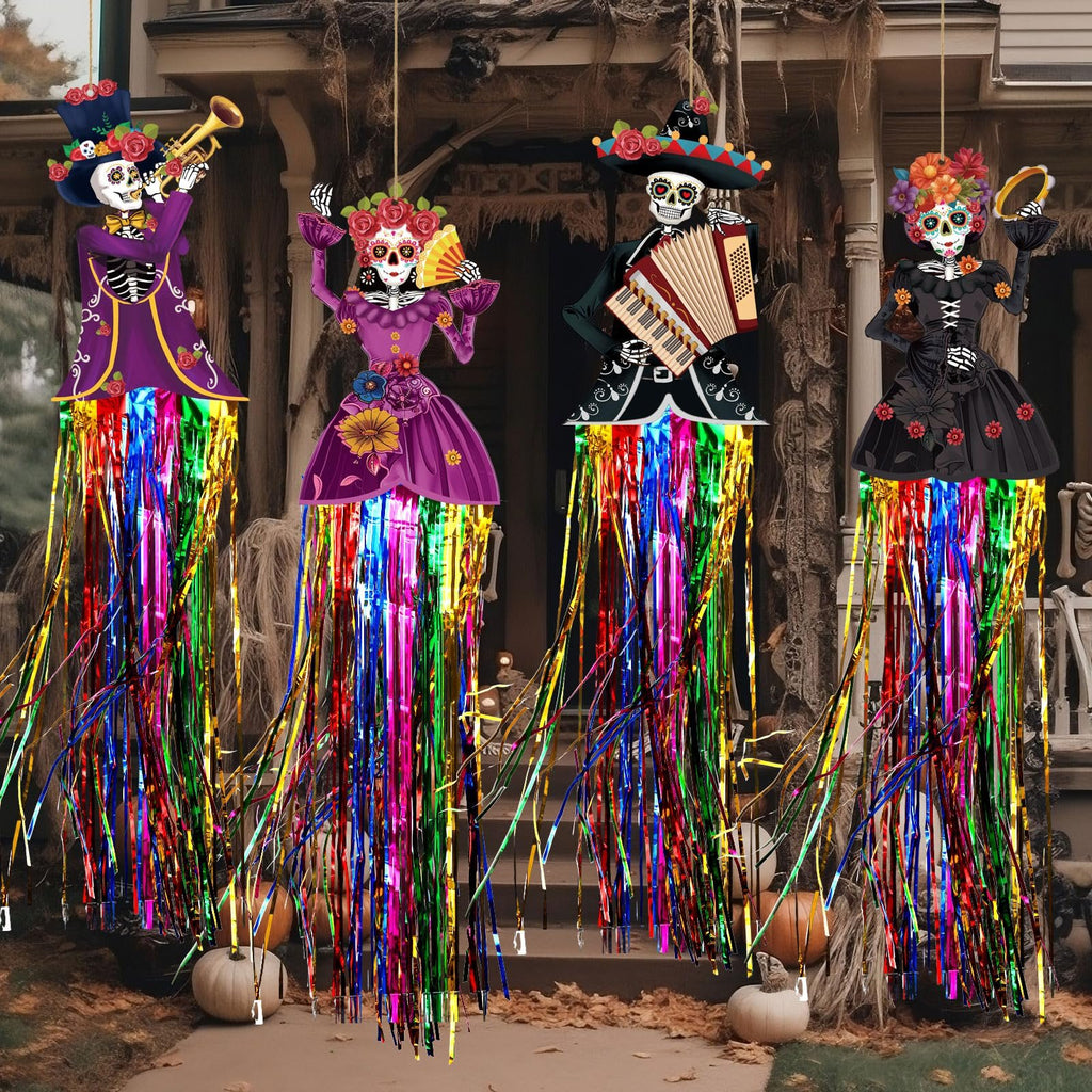 Four Day of the Dead sugar skull hanging decorations with colorful fringe tassels displayed on a porch with pumpkins and autumn leaves.