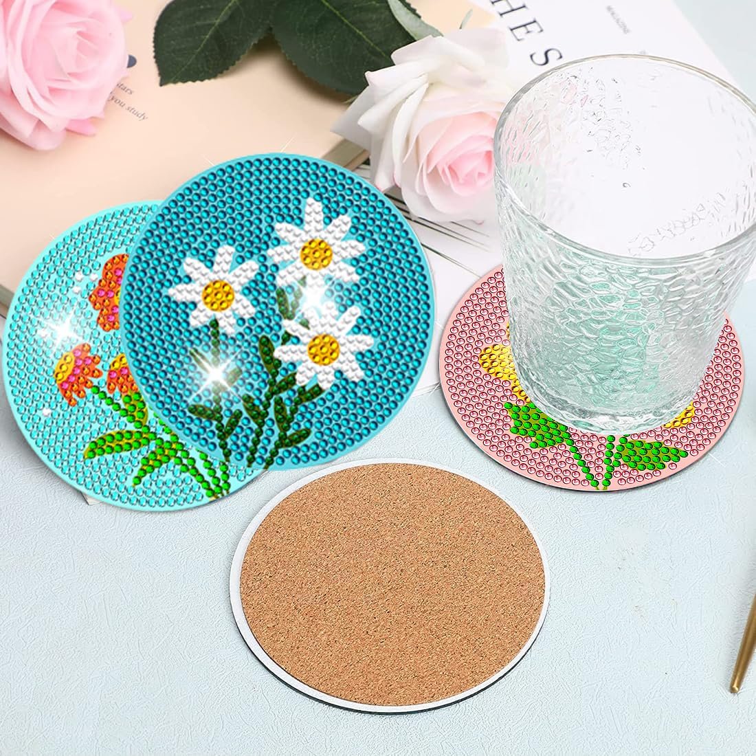 Diamond art coasters with flower designs and cork backing, one coaster holds a glass.