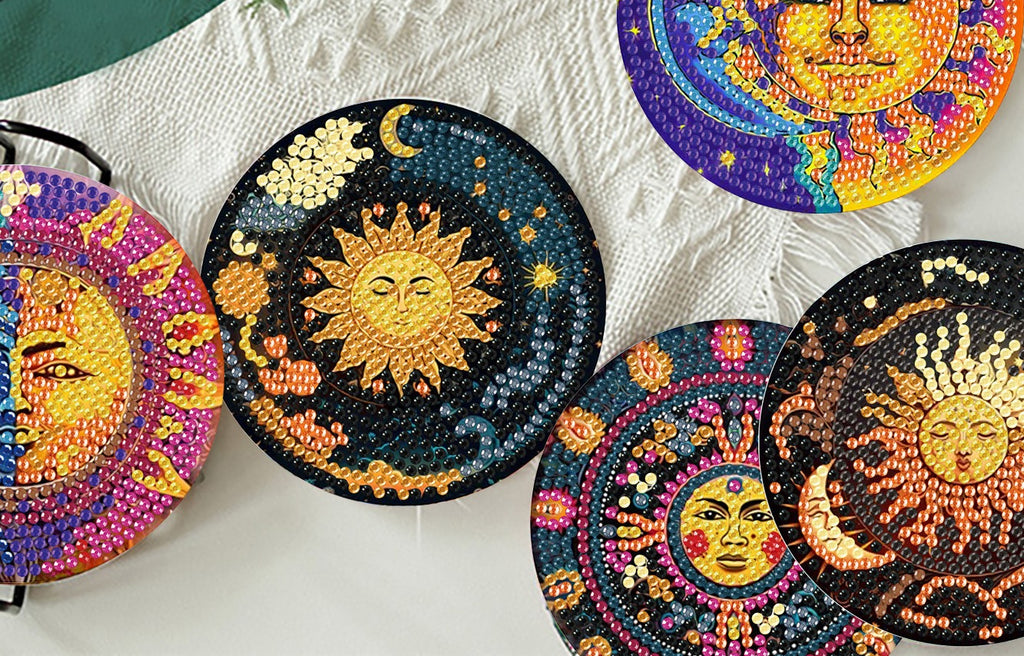 Diamond art coasters with sun and moon designs arranged on a textured surface.