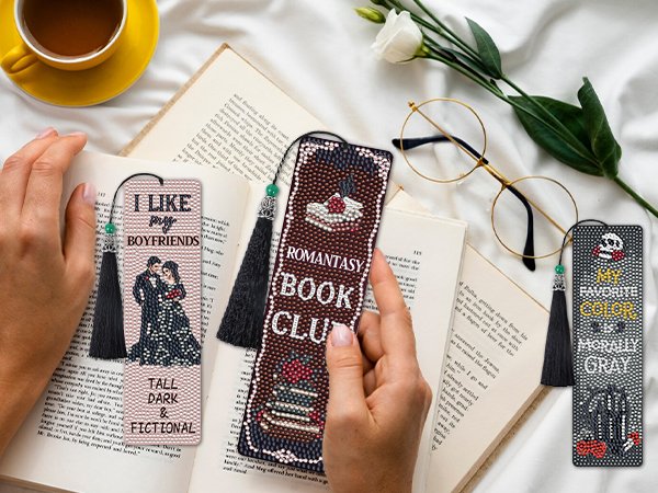 Diamond painting bookmarks with tassels, one reads 'I Like My Boyfriends Tall Dark & Fictional', another 'Romantasy Book Club', and a skull with 'My Favorite Color Is Morally Gray'.