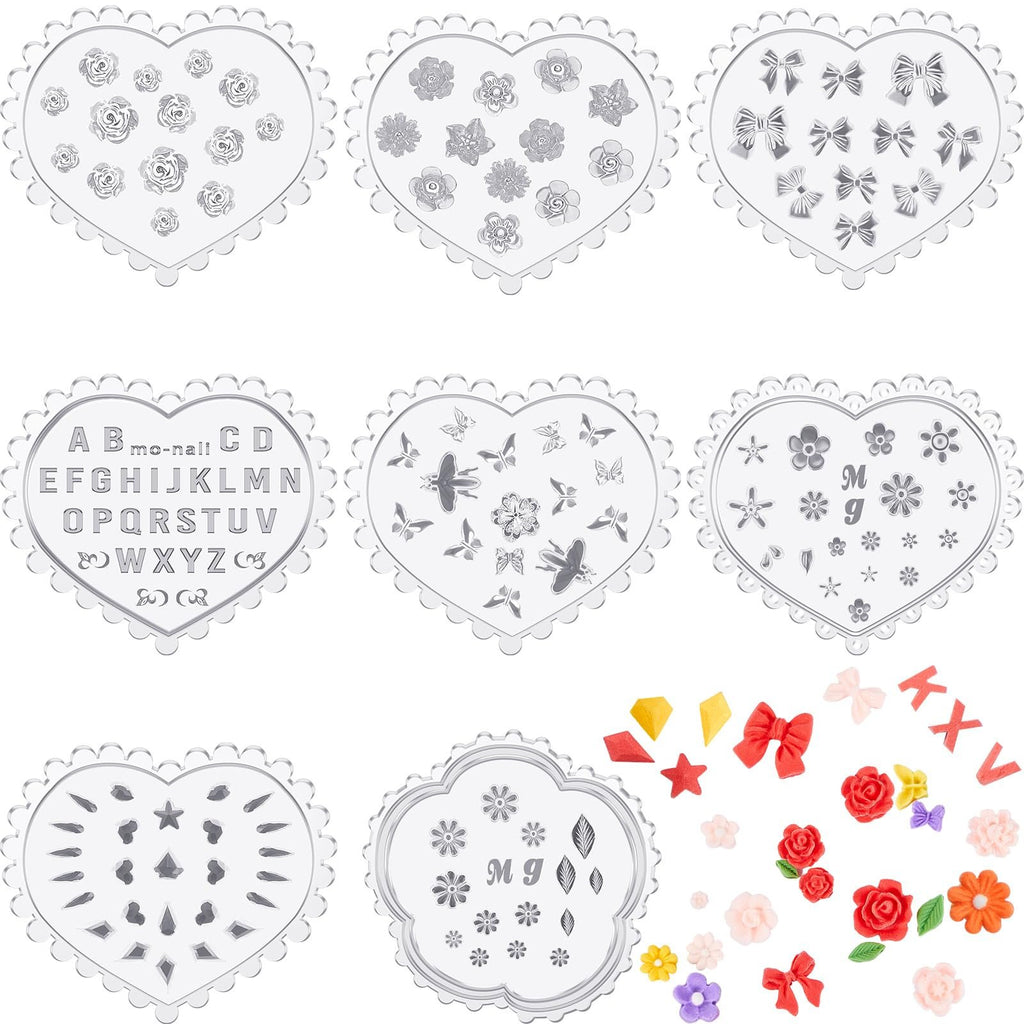 Set of silicone molds in heart shapes with various designs including flowers, bows, butterflies, and letters, plus scattered colorful craft embellishments.