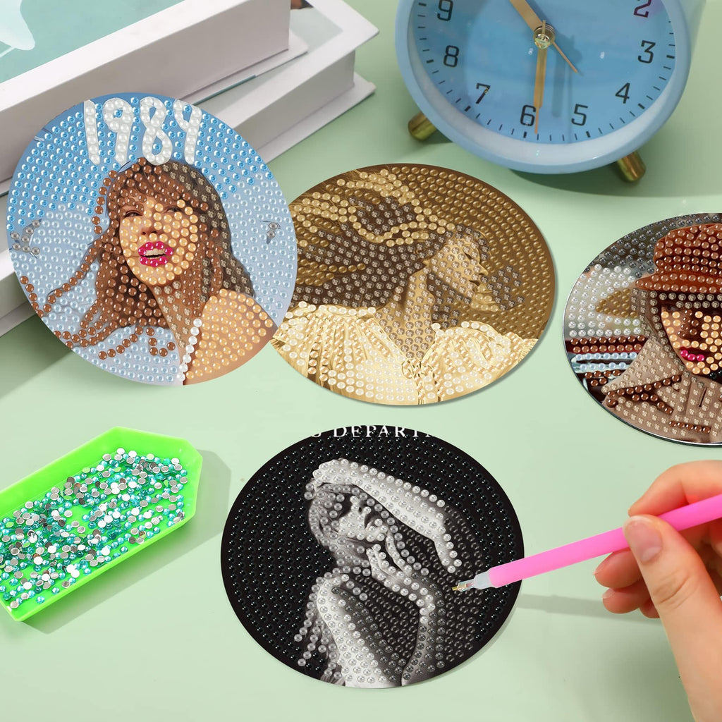 Diamond art coasters featuring portraits and the number 1989, with a tray of rhinestones and a pink applicator tool.