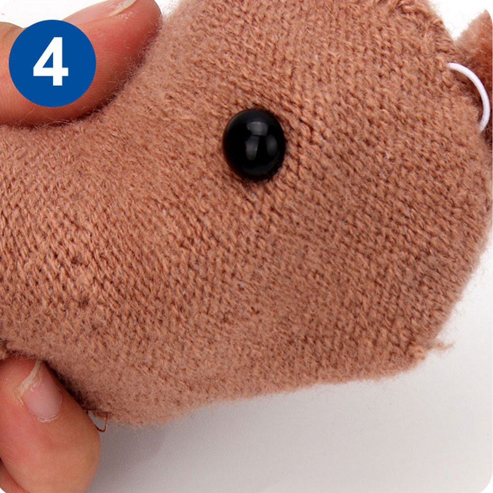 Close-up of a brown plush toy with a black safety eye, held by fingers, with a blue circle containing the number 4.