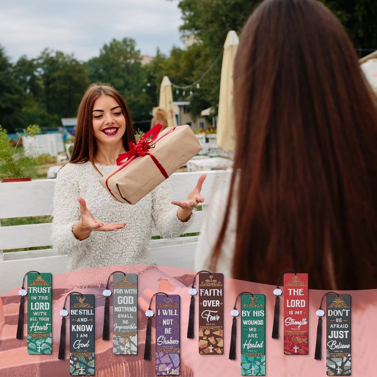Two women exchanging a gift, with eight diamond art bookmarks displayed in the foreground.