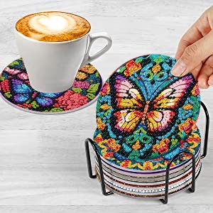 Butterfly diamond painting coasters in a holder with a coffee cup on one coaster
