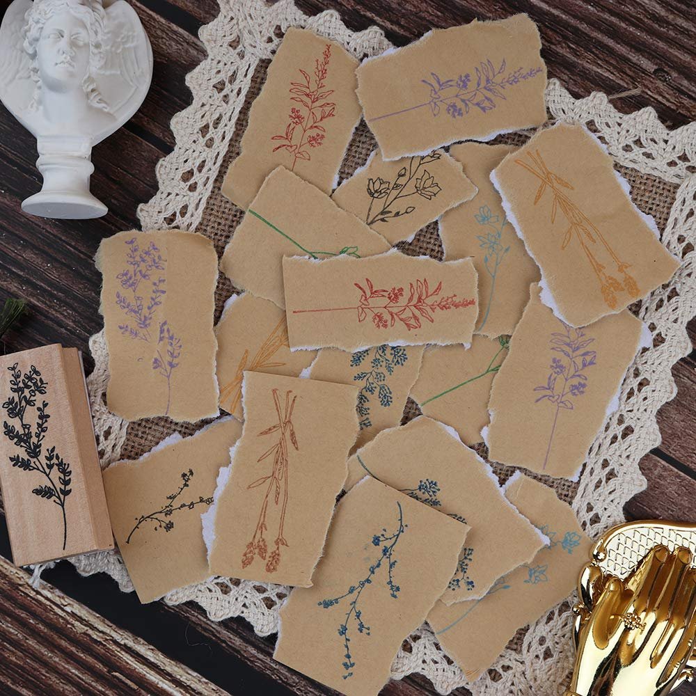 Wood mounted rubber stamp with a sprig of leaves next to torn paper pieces stamped with various floral and plant patterns in different colors.