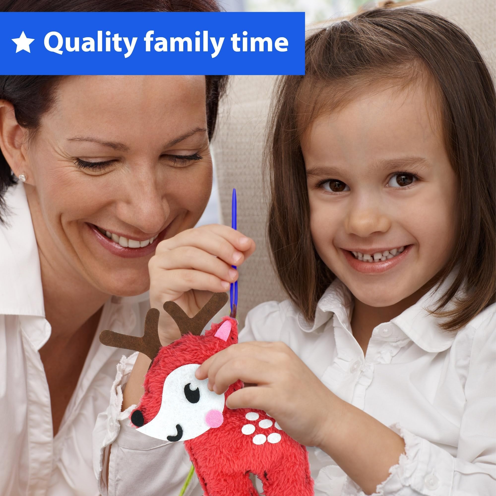 Woman and child sewing a red felt reindeer stuffed doll together, with a blue needle tool.