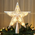 Glittered star Christmas tree topper with warm white lights, placed on a decorated tree.