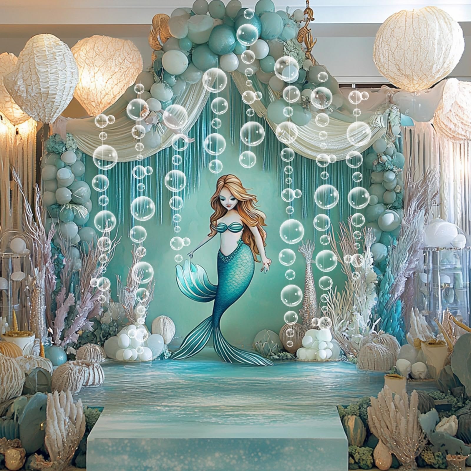 Mermaid-themed party backdrop with balloons, bubble garlands, and a mermaid illustration.