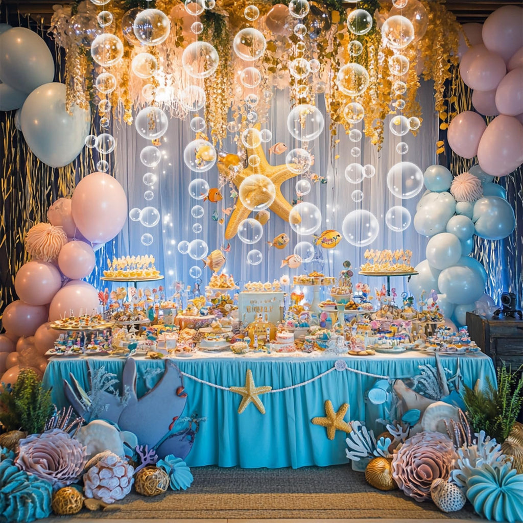 Underwater themed party dessert table with bubble garlands, balloons, starfish, and fish decorations.